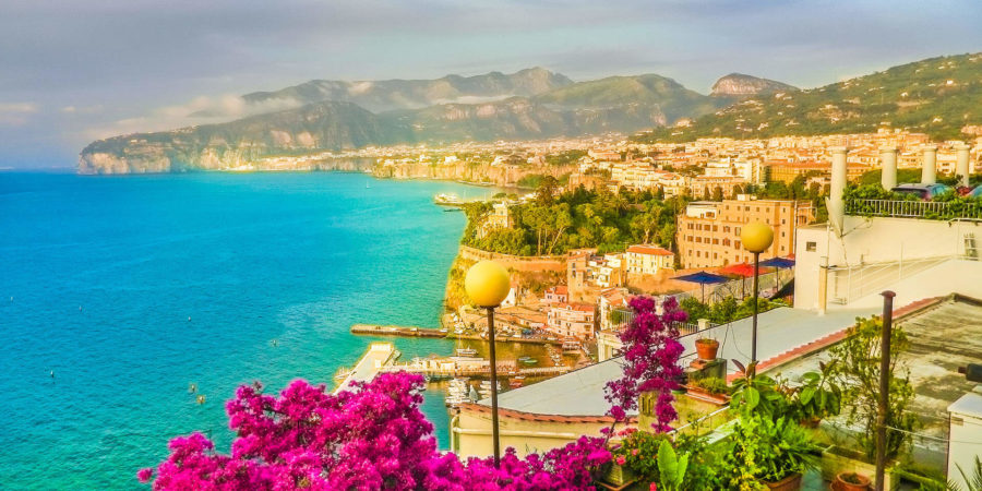 Vista de Sorrento com mar, flores e cidade ao funo