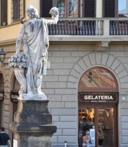 Fachada da gelateria Santa Trinita em Florença, com estátua da ponte santa Trinita em primeiro plano