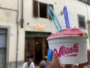 Gelato italiano segurado por uma mão em frente à Vivoli, na cidade de Florença, itália