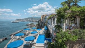 Vista panorâmica com piscina e mar do hotel bellevue syrene em sorrento