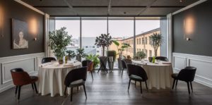 Mesas e ambiente elegante do restaurante Enrico Bartlini al MUDEC em Milão