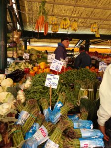 Frutas e vegetais coloridos, com trabalhadores ao fundo, no mercado de rialto, em Veneza, uma dos locais para quem busca o que fazer em Veneza em 2 dias