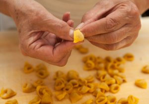 Mão fazendo tortellini, um das comidas típicas italianas, orignal da Emilia Romagna