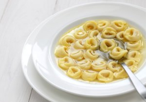 Prato de tortellini in brodo, com talher ao lado