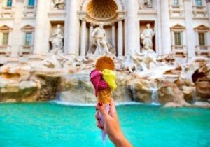 Gelato italiano colorido em rosa e amarelo, com Fontana di Trevi de Roma ao fundo