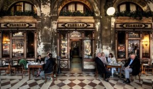 Fachada do Caffe Florian em Veneza, com pessoas sentadas na mesa
