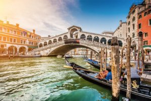 Vista lateral da Ponte rialto em Veneza, com gôndola em primeiro plano