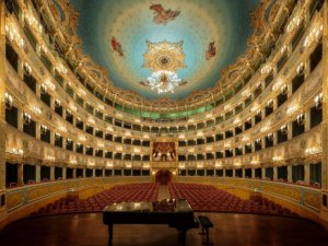 Vista geral com plateia, balcões dourados e teto do teatro La Fenice, em Veneza