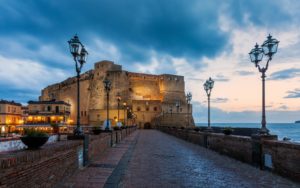 Castel del 'Uovo, em Nápoles, Itália, visto de longe, ao crepúsculo.