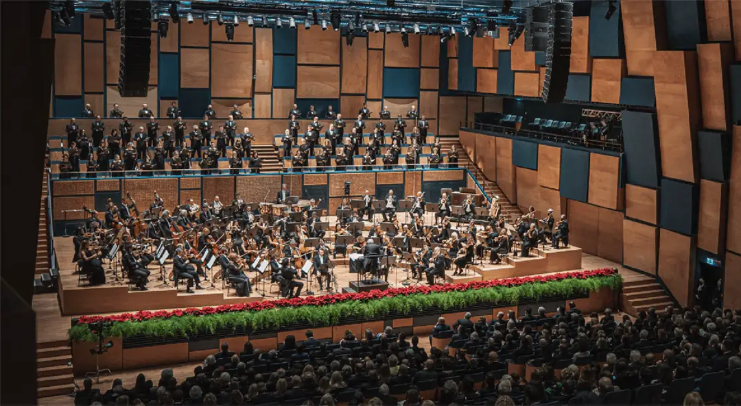Symphonic concert at the Teatro del Maggio Musicale Fiorentino in Florence, with orchestra and choir on a modern stage during spring